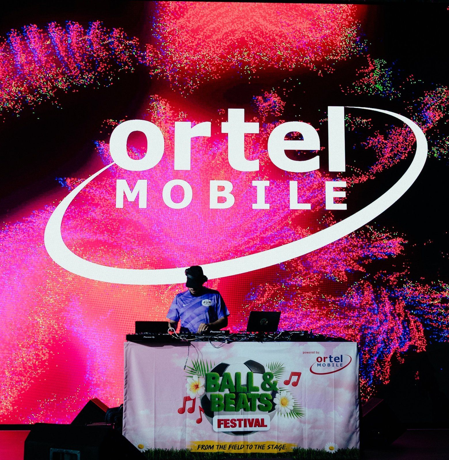 DJ am Pult mit Ball-&-Beats-Festival-Banner, dahinter eine große LED-Wand mit Ortel-Mobile-Logo in Pink und Rot