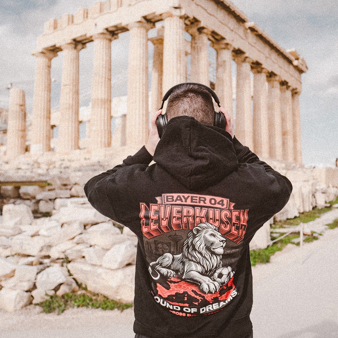 Fan mit Kopfhörern im schwarzen Sound-of-Dreams-Hoodie mit Löwenmotiv vor der Akropolis in Athen