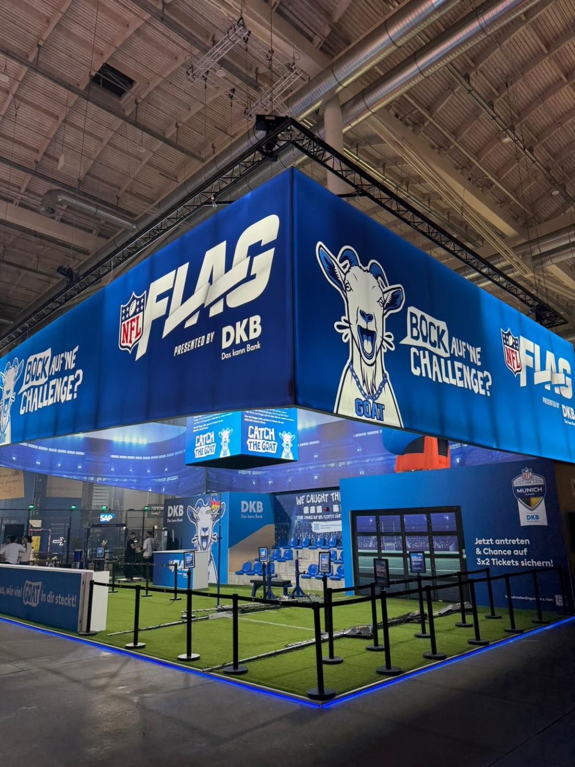 DKB-Stand auf dem OMR Festival mit leuchtendem NFL-Flag-Banner und Flag-Combine auf Kunstrasen
