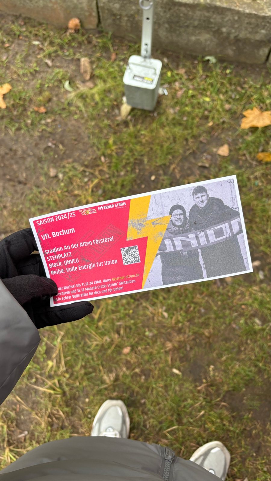Hand im Handschuh hält das personalisierte Retro-Ticket von Eiserner Strom zum Spiel gegen den VfL Bochum