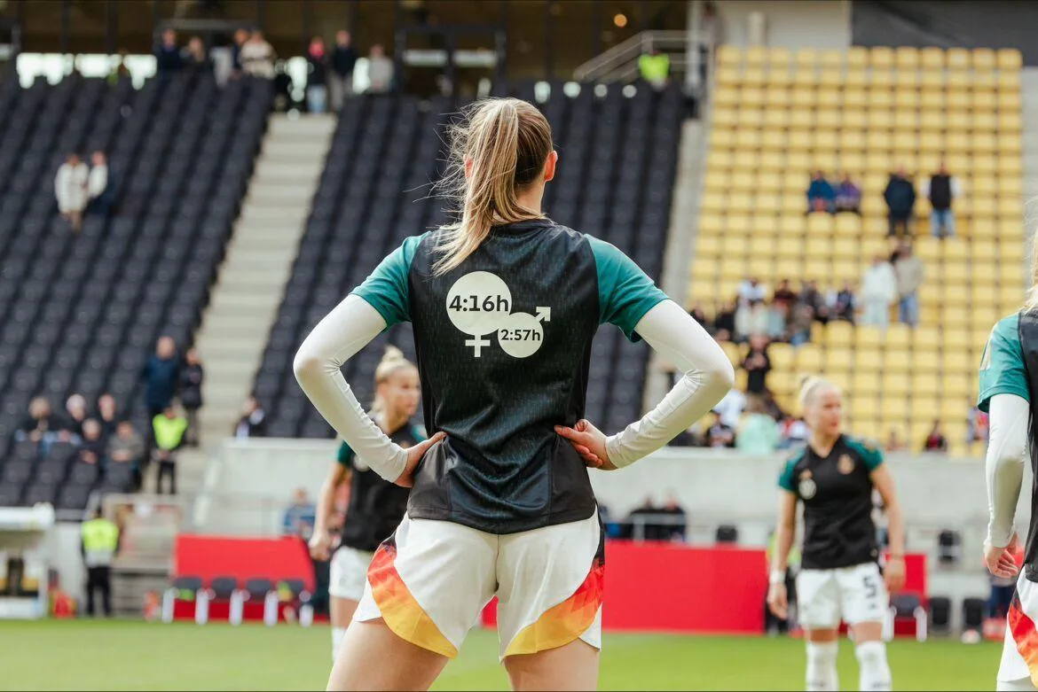 Spielerin der DFB-Frauen im Aufwärmtrikot mit den Care-Arbeit-Zeiten 4:16 h und 2:57 h auf dem Rücken