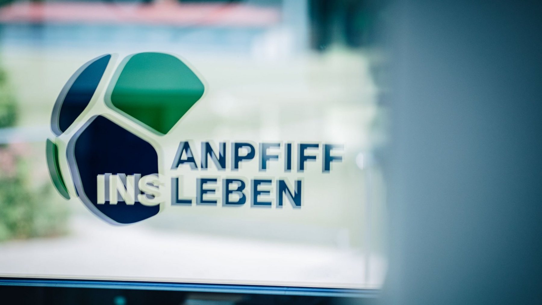 Logo von Anpfiff ins Leben auf einer Glasscheibe