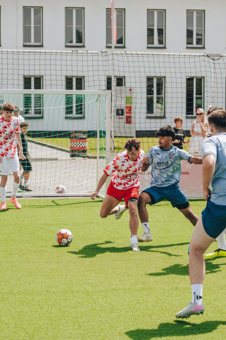 Zweikampf im Käfig zwischen Royal Roots und Urban Kicks, beide Trikots mit Ortel-Logo, Zuschauer am Netz – ech