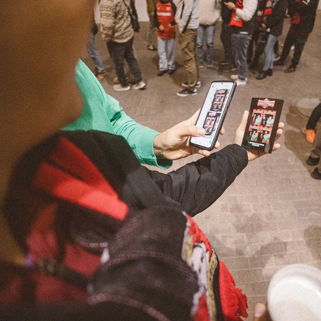 Fans vergleichen Fotobox-Streifen auf Papier und auf dem Smartphone