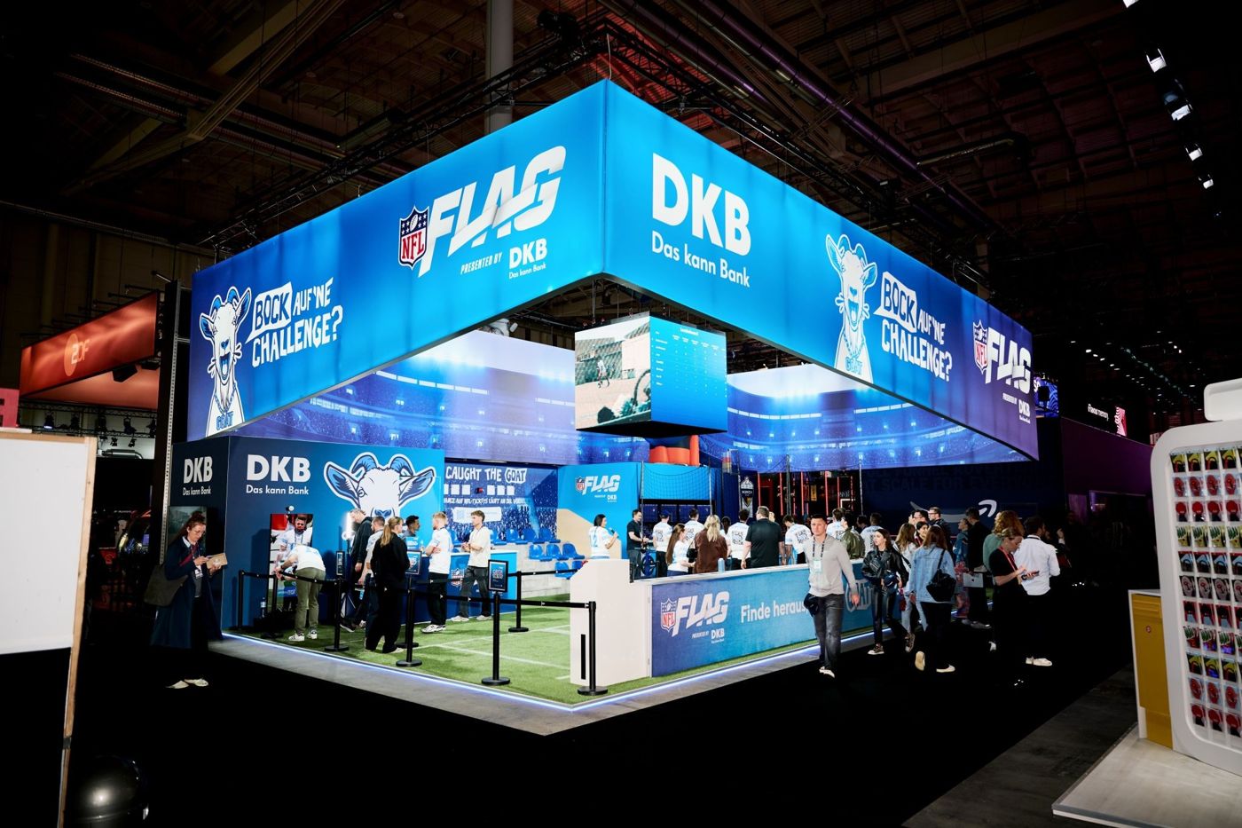 Blau beleuchteter DKB-Flag-Stand beim OMR Festival mit Kunstrasenfeld und Besucher*innen