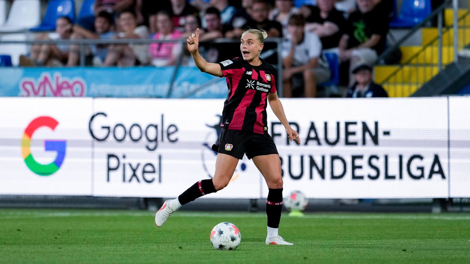 Spielerin von Bayer 04 Leverkusen am Ball, dahinter die Bande mit „Google Pixel Frauen-Bundesliga“