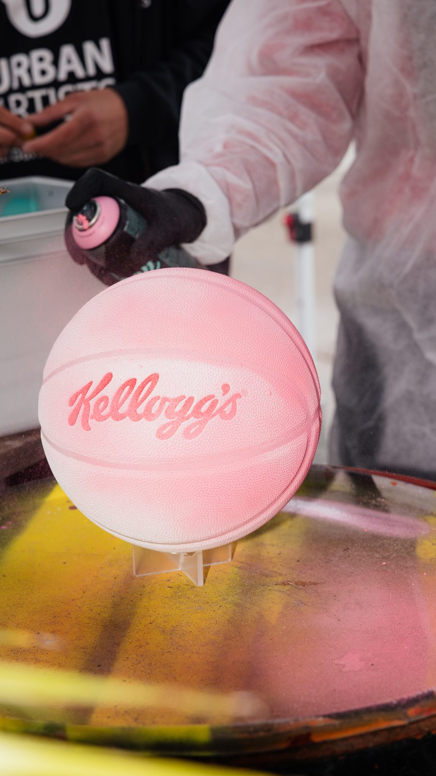 Ein rosa Kellogg's-Basketball wird mit Sprühfarbe gestaltet