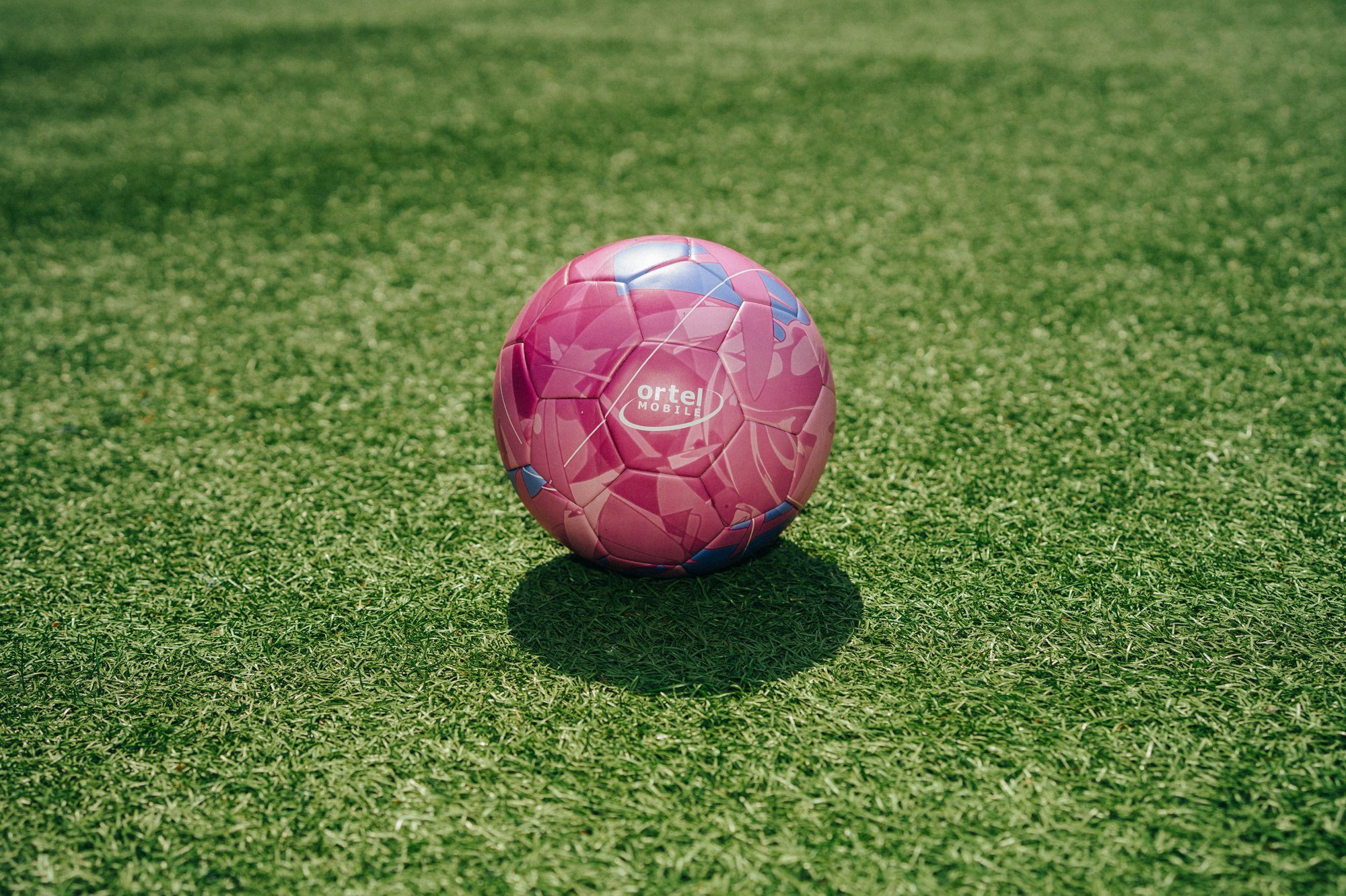 Pinker Ball-&-Beats-Spielball mit Ortel-Logo auf Kunstrasen