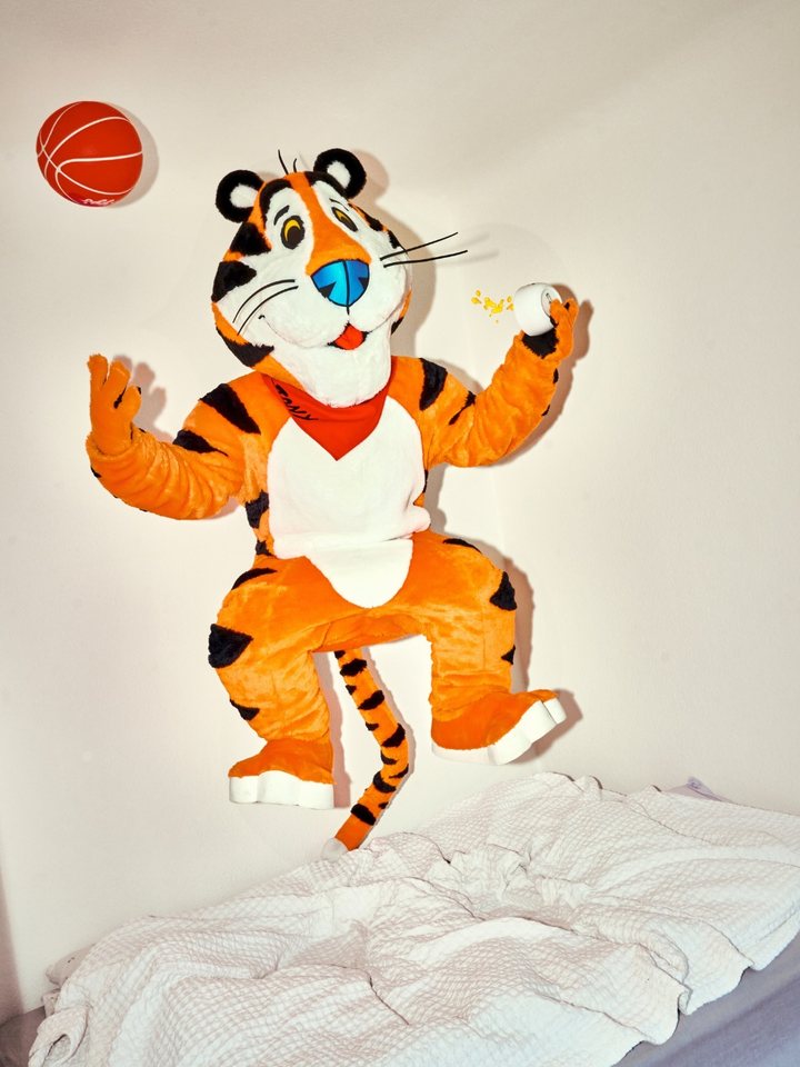 Tony der Tiger springt mit Basketball über ein Bett