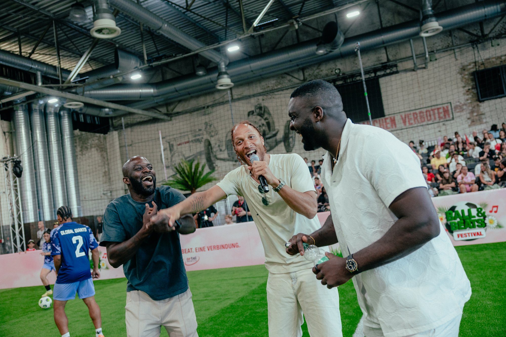 Lachende Coaches am Spielfeldrand beim Ball & Beats Festival
