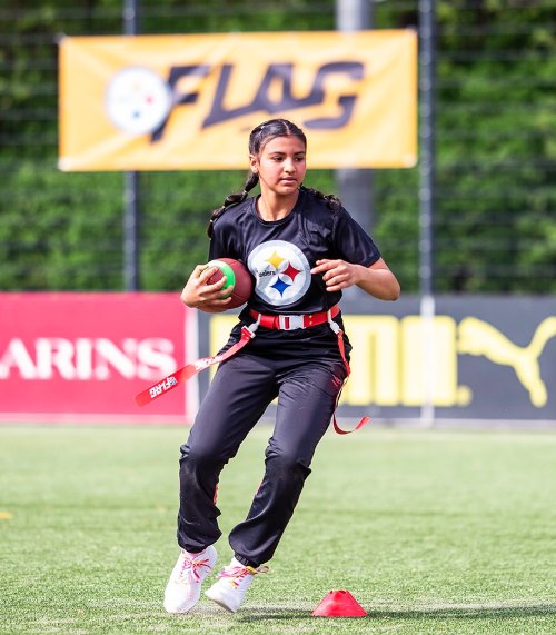 Jugendliche im Steelers-Shirt läuft mit Ball und Flag-Gürtel über den Kunstrasen