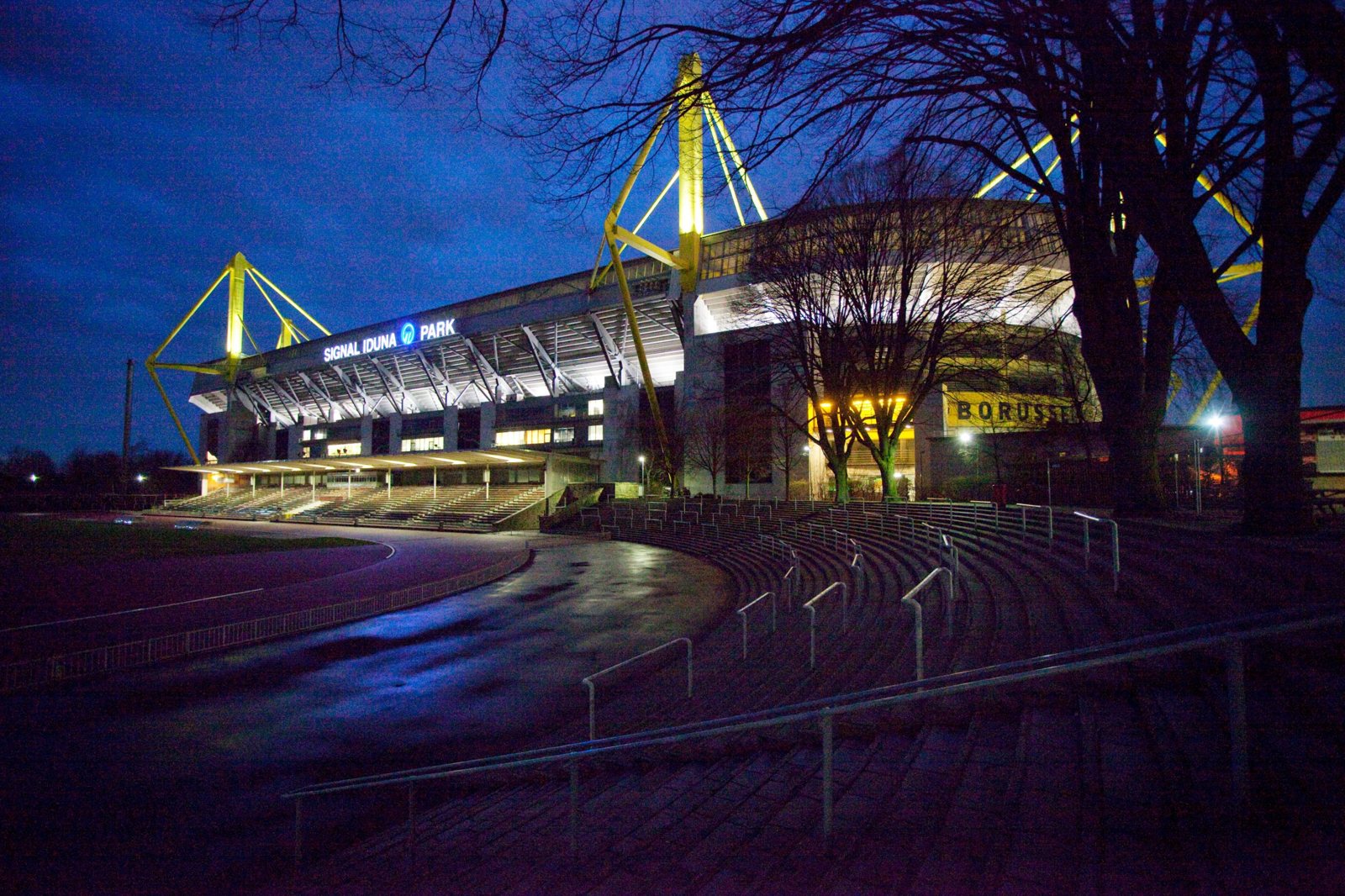 Der beleuchtete Signal Iduna Park in Dortmund am Abend mit den gelben Stahlpylonen