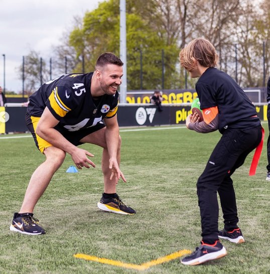 Steelers-Spieler mit der Nummer 45 übt beim Flag-Football-Camp mit einem Jugendlichen